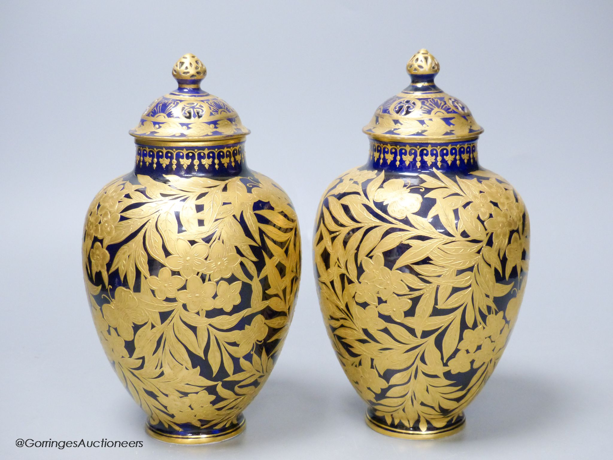 A pair of Crown Derby blue and gilt vases, both with restored lids, height 21cm